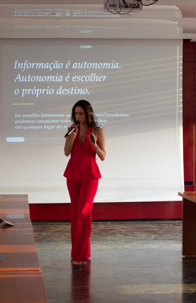 Dra. Anne Rocha em palestra, ao microfone